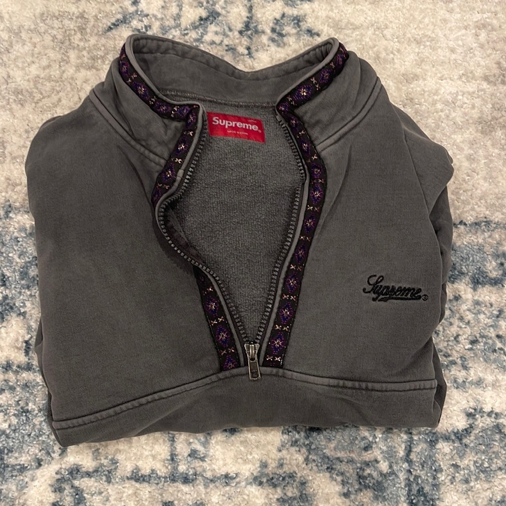 supreme grey half zip with detailing around the collar